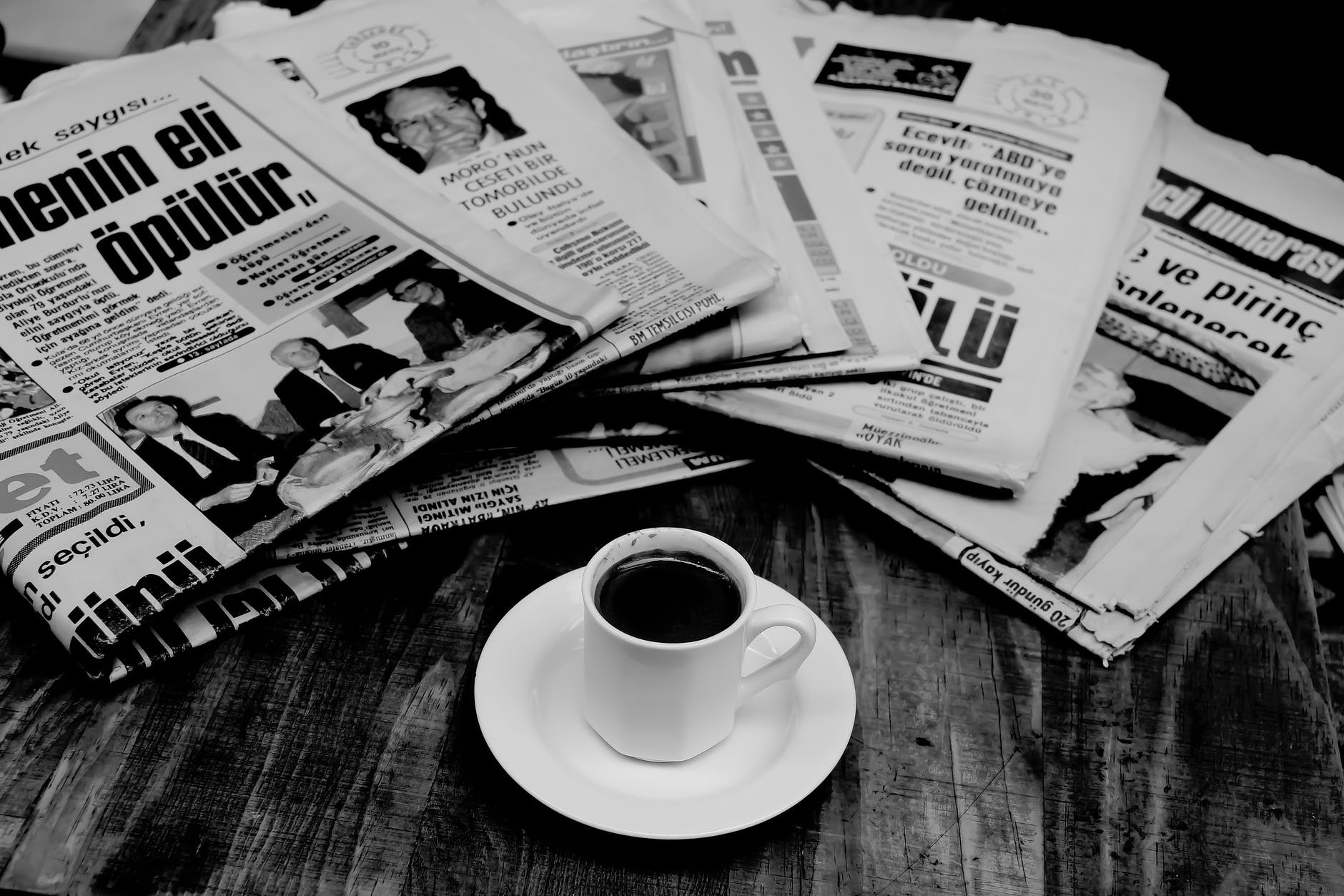 folded newspapers and a cup of coffee